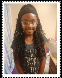 A young girl in glasses is smiling for the camera.